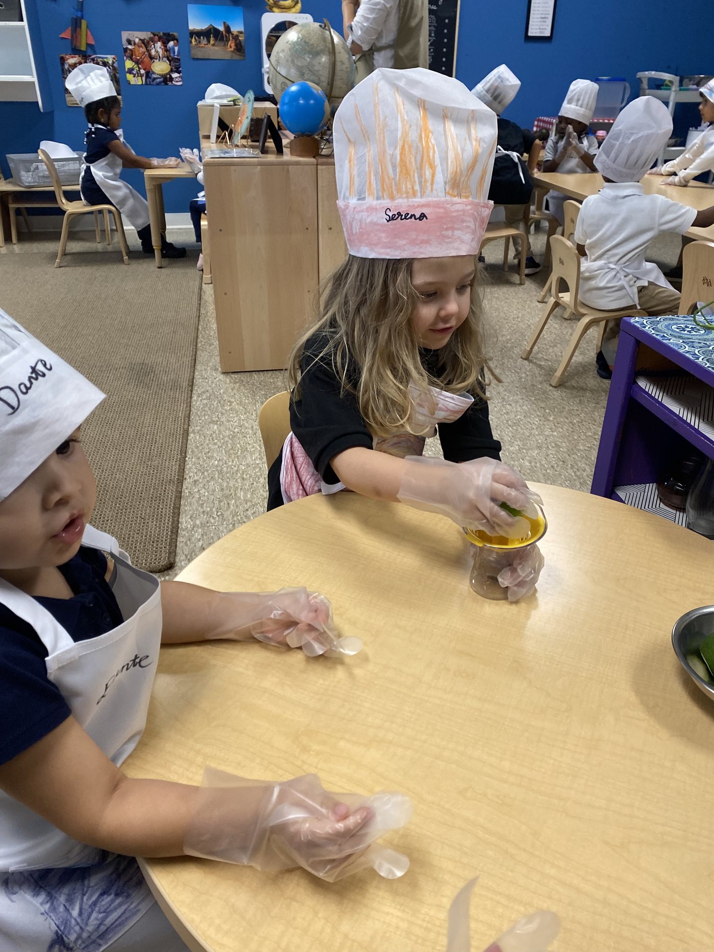 A Seven Oaks student in a paper chef hat mixes ingredients during a cooking lesson